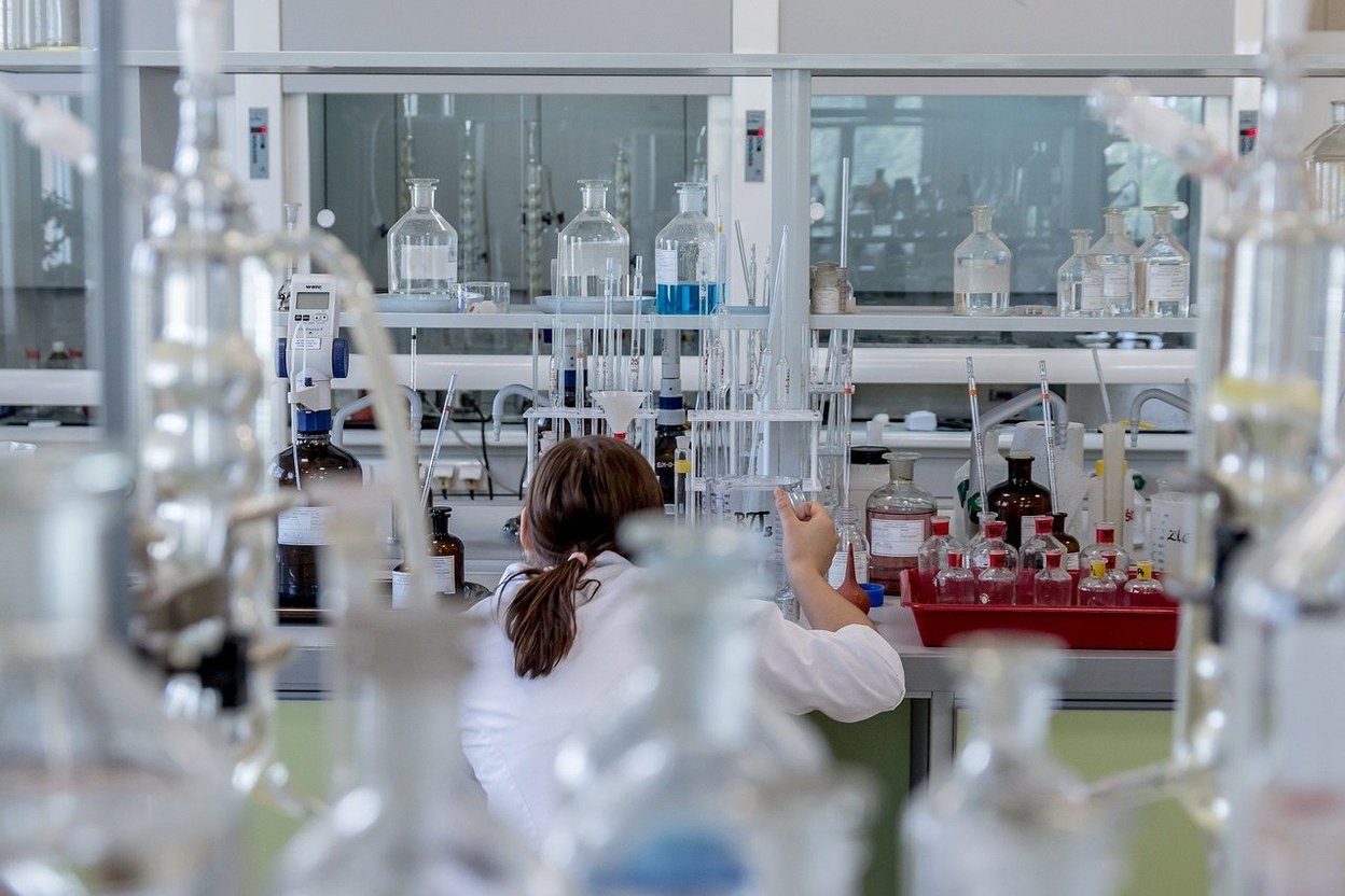A lab worker handling glassware in a testing laboratory