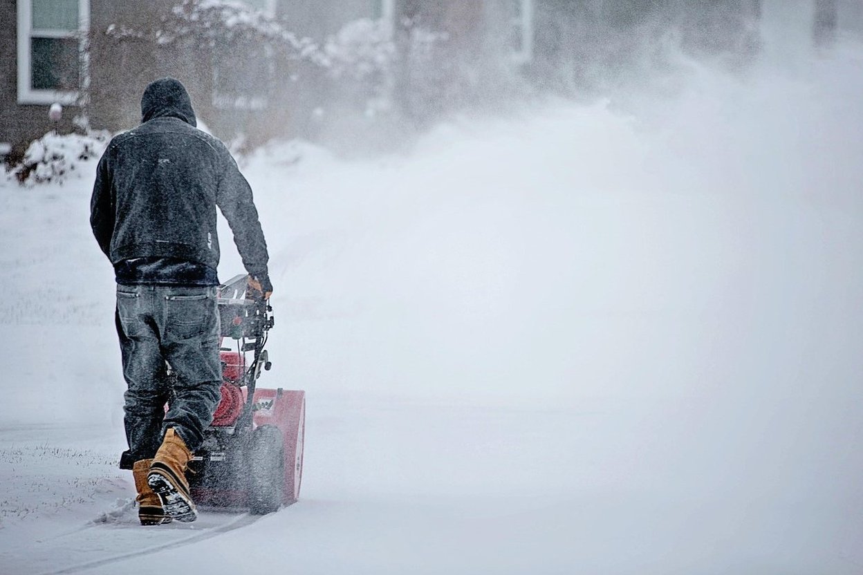 A person clearing deep snow with a snowblower